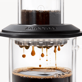 AeroPress Premium coffee maker with coffee being brewed. #color_black