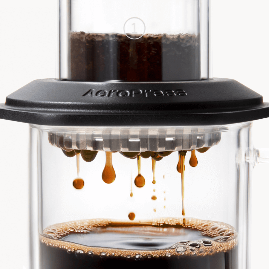 AeroPress Premium coffee maker with coffee being brewed. #color_black