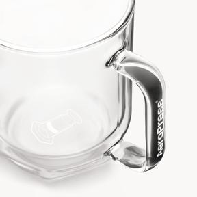 Clear glass AeroPress Mug with handle on a white background