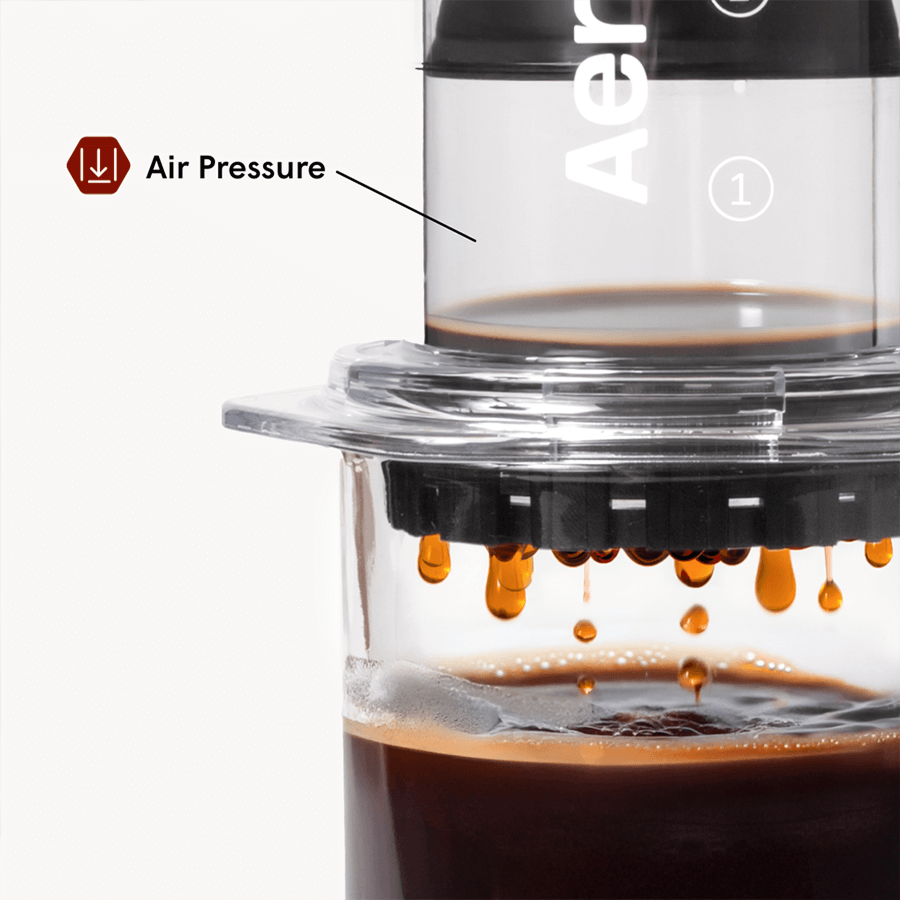 Coffee brewing device with air pressure indicator and coffee dripping into a glass container.
