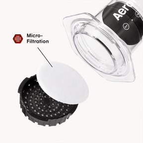 Aeropress coffee maker with a focus on micro-filtration component on a white background #color_clear