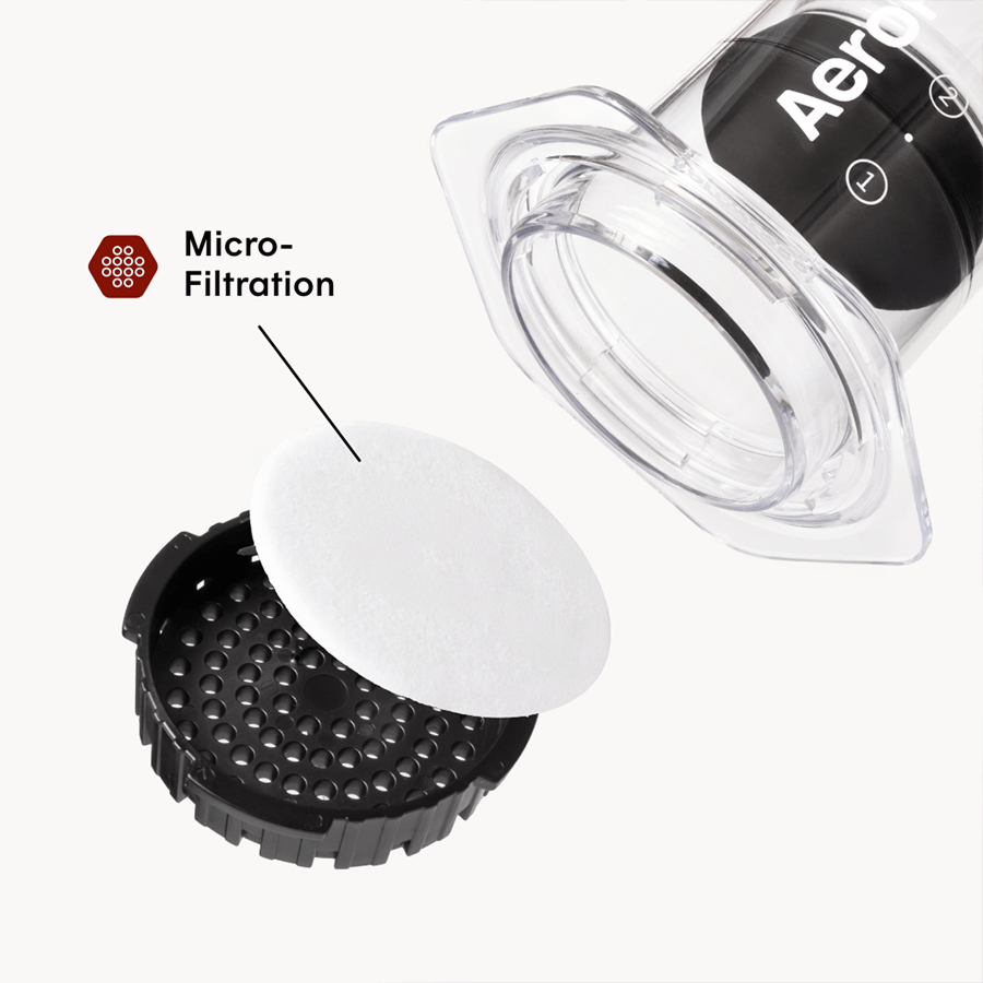 Aeropress coffee maker with a focus on micro-filtration component on a white background #color_clear