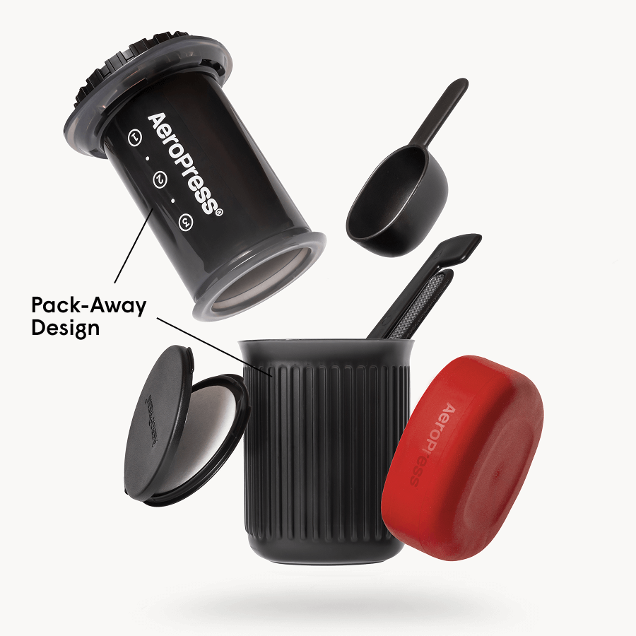 AeroPress Go coffee maker with red lid and black scoop on a white background
