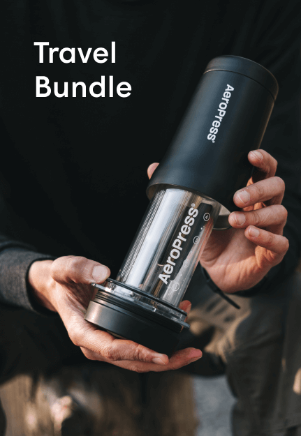 Hands holding AeroPress Go Plus travel coffee maker